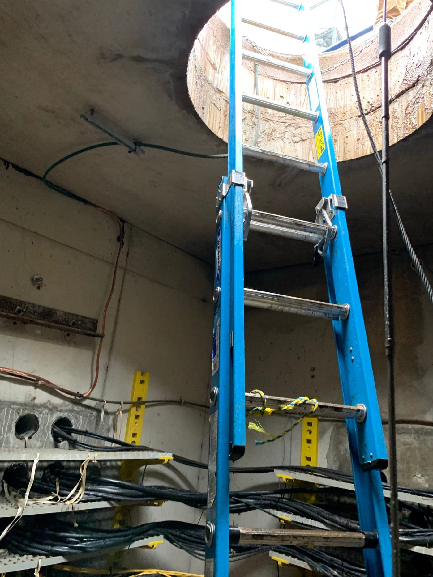 Inside a concrete cable vault with racked cables during a cable installation