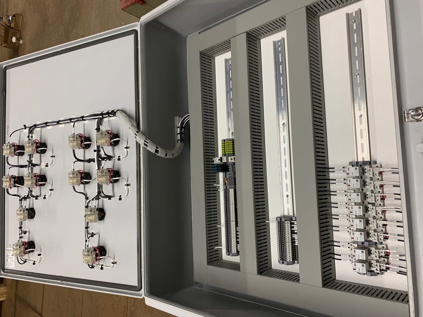 Large custom control panel under assembly in the Electrisource shop, with DIN-rail components, wire duct, and labeled terminal blocks