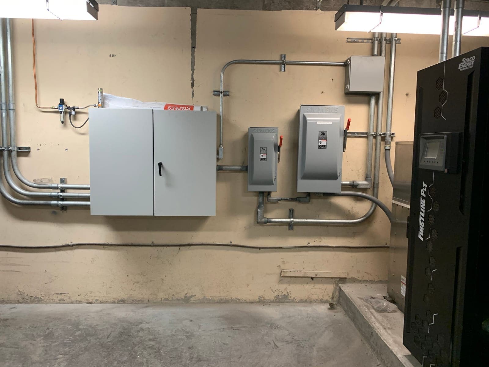 New wall-mounted enclosure, safety switches, and conduit installed in a facility electrical room