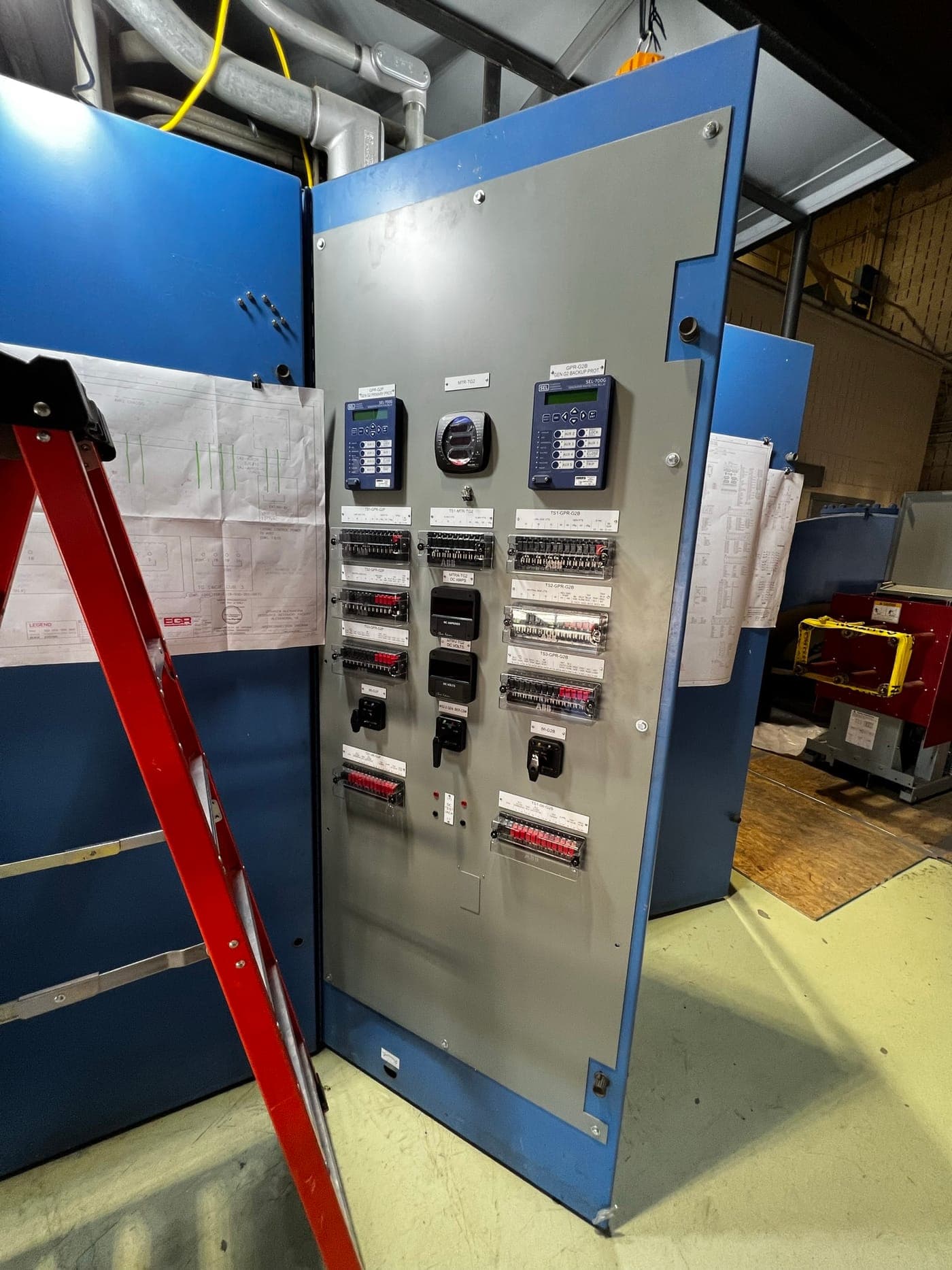 Upgraded protection relay panel with new digital relays and labeled test switches